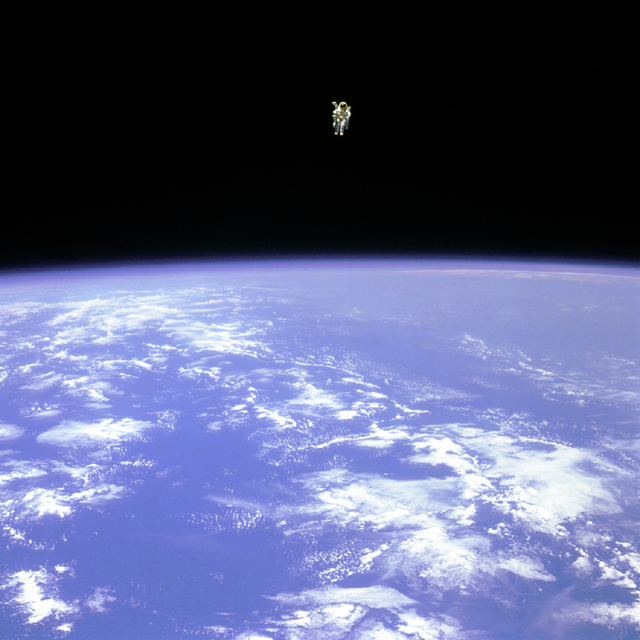 NASA photo of Earth from space with tiny astronaut floating alone in space